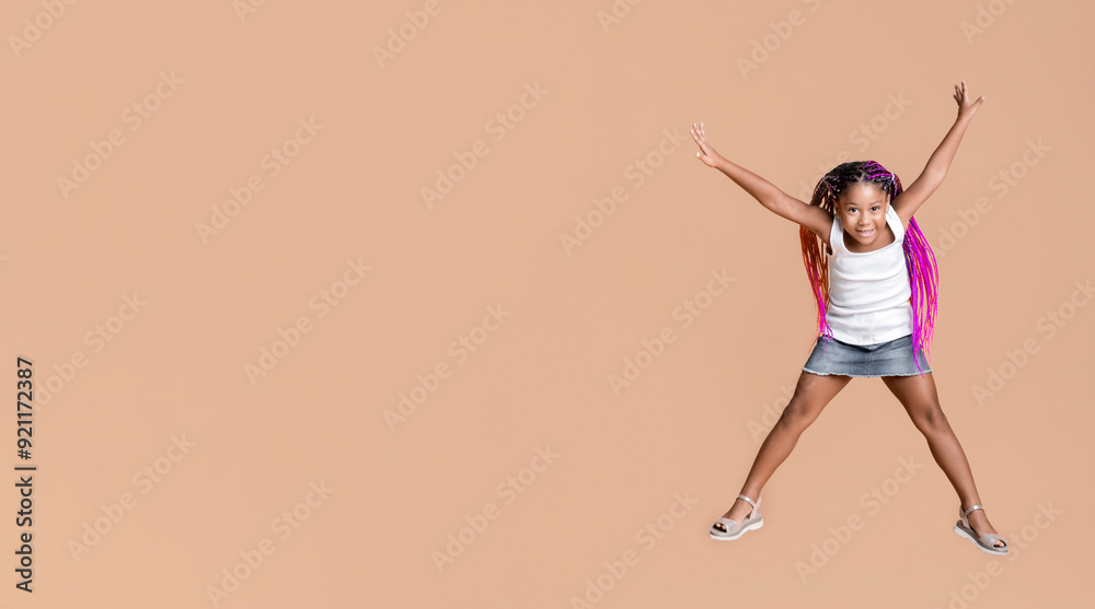 Like a star. Cute little african american girl jumping with her hands ...