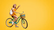 © Prostock-studio - Summer Sale. Excited Young Girl Riding Vintage Bicycle And Pointing Aside At Copy Space Over Yellow Background