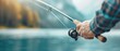 © 2D_Jungle - a fisherman holding a rod and reel by a picturesque lake, copy space, natural lighting