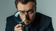 © orendesain99 - A businessman is holding a magnifying glass and looking at his face