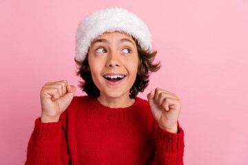 Poster - Photo of positive kid boy look empty space raise fists up on christmas isolated pastel color background