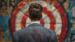 © Evgeniia - A businessman stands in front of a target. Background for design.