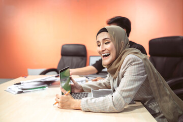 business muslim and asian woman and man have meeting. funny beautiful islam person laugh at organization plan in conference room. happy fun professional employee showing team present company project