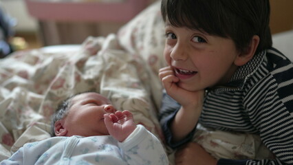 Older brother gazing affectionately at newborn baby, touching gently, bonding moment, indoor bedroom setting, expressions of love and curiosity, family connection, new sibling relationship