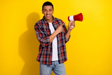 Sticker - Photo of nice man with short haircut dressed plaid shirt indicating at megaphone announcing sale isolated on yellow color background