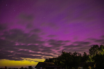 Wall Mural - bright red-violet sky northern lights and sun flares starry sky