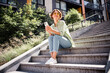 © deagreez - Photo of cheerful cute girl wearing trendy clothes outfit sitting on stairs city center relax rest sunny weather outdoors