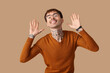 © Pixel-Shot - Happy young man on brown background
