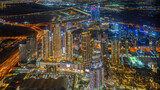 Dubai city center downtown district aerial panorama with skysrapers glowing with neon lights in the night, UAE