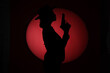 © Pixel-Shot - Silhouette of female spy with gun on dark background