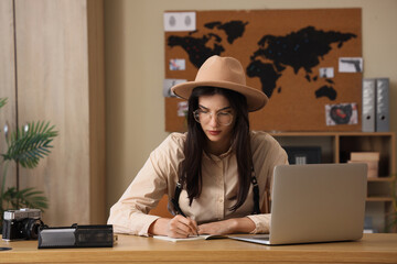 Wall Mural - Female spy writing on notebook in office