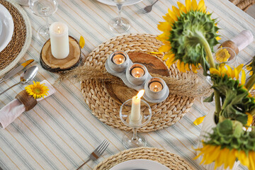 Canvas Print - Burning candles and sunflowers on dining table