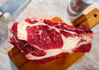 Poster - Fresh raw beef steak on wooden background with herbs