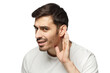 © Damir Khabirov - Young man pressing hand to ear trying to hear something better