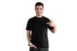 © Damir Khabirov - Young handsome man smiling while pointing with index finger to black t-shirt, copy space for ads