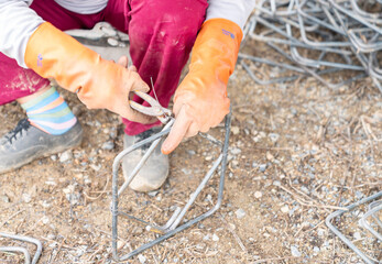 Worker wire bundle steel rod for construction job.