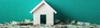 © Chanoknan - A miniature house model sits atop a pile of money, symbolizing real estate investment and financial growth.