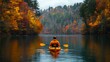 © Watasiwa - Person kayaking on a calm lake surrounded by autumn foliage