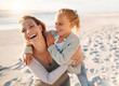 © peopleimages.com - Laughing, mother and child hug at beach with travel, holiday and summer vacation in Florida. Happy, smile and bonding by sea with love, care and support on family trip by ocean with embrace.