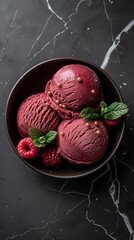 Wall Mural - Red ice cream scoops are elegantly displayed in a bowl, garnished with fresh berries and mint leaves, set against a striking black background