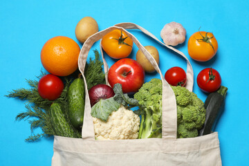 Wall Mural - Delivery of vegetarian products. Bag with different vegetables and fruits on light blue background, top view