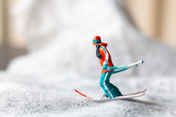 miniature figurine of a skier in motion skiing across a white snowy landscape