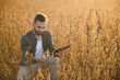 © Serhii - Farmer agronomist on a soybean field. Agricultural industry.