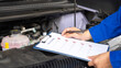 © Nattawit - Action of a mechanic worker in blue uniform is using a pen to checking on safety checklist form to verify the condition of EV car system (blur background). Industrial working scene, selective focus.