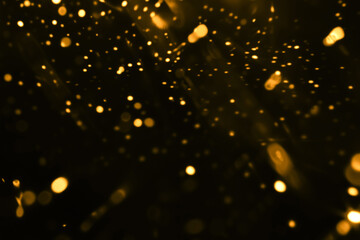 Wall Mural - Black background with lots of golden lights. Abstract transition or overlay light effect with vintage gold bokeh, retro light leak