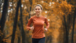 © Stefan - Happy smiling beautiful Caucasian woman running or jogging on trail in autumn park or forest during fall season, female athlete, runner or jogger training or exercising in nature, fitness and sport