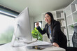 © wichayada - Middle-aged Businesswoman Happily Celebrates a Job Well Done in Modern Office Environment