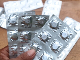 someone is holding several medicines in aluminum foil packaging