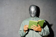 © GVS - Mystery man with duct tape face relax and reading book over gray background