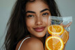 © StockLab - Young brunette woman in her 20s, holding an IV vitamin bag with orange slices, promoting rejuvenation and revitalization  with IV vitamin drip