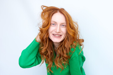 Canvas Print - A woman with red hair is smiling and wearing a green sweater