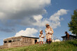 © standret - Wooden little building behind. Mother and daughter are together on the farm with goats