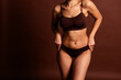 © deagreez - Cropped photo of plus size lady underwear lingerie accepting cellulite skin emtpy space isolated brown color background