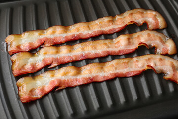 Wall Mural - Slices of bacon on grill, closeup view