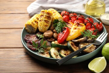 Delicious grilled vegetables served on wooden table, closeup