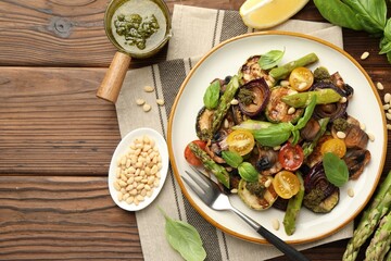 Wall Mural - Delicious salad with grilled vegetables, basil, pesto sauce, pine nuts and fork on wooden table, flat lay. Space for text