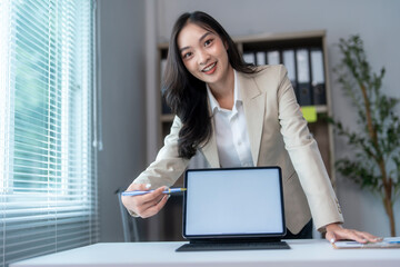 Businesswoman pointing at digital tablet with blank screen presenting new project