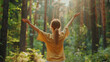 © NooPaew - Free woman with open arms breathing clean air in a nature forest, viewed from the back, celebrating happiness and wellness