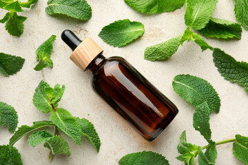 Wall Mural - Bottle of essential oil and mint on light textured table, flat lay