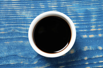 Balsamic vinegar on blue wooden table, top view