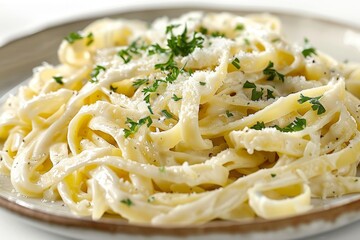 A plate of creamy fettuccine Alfredo garnished with parsley and Parmesan cheese,