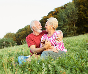 Wall Mural - woman man outdoor senior couple happy lifestyle retirement together smiling love reading nature book