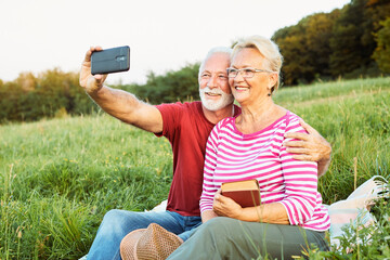Wall Mural - woman man outdoor senior couple happy lifestyle retirement together smiling love selfie camera matur