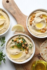 Wall Mural - Delicious hummus with olive oil and chickpeas served on white table, flat lay