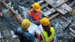 © somneuk - A diverse team of project managers discussing construction plans at a busy construction site. High-quality materials and a variety of tools are visible,