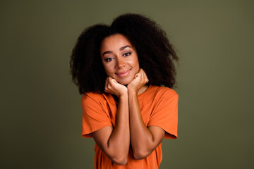 Sticker - Photo of good mood nice woman with perming coiffure dressed orange shirt holding fists under chin isolated on dark khaki background